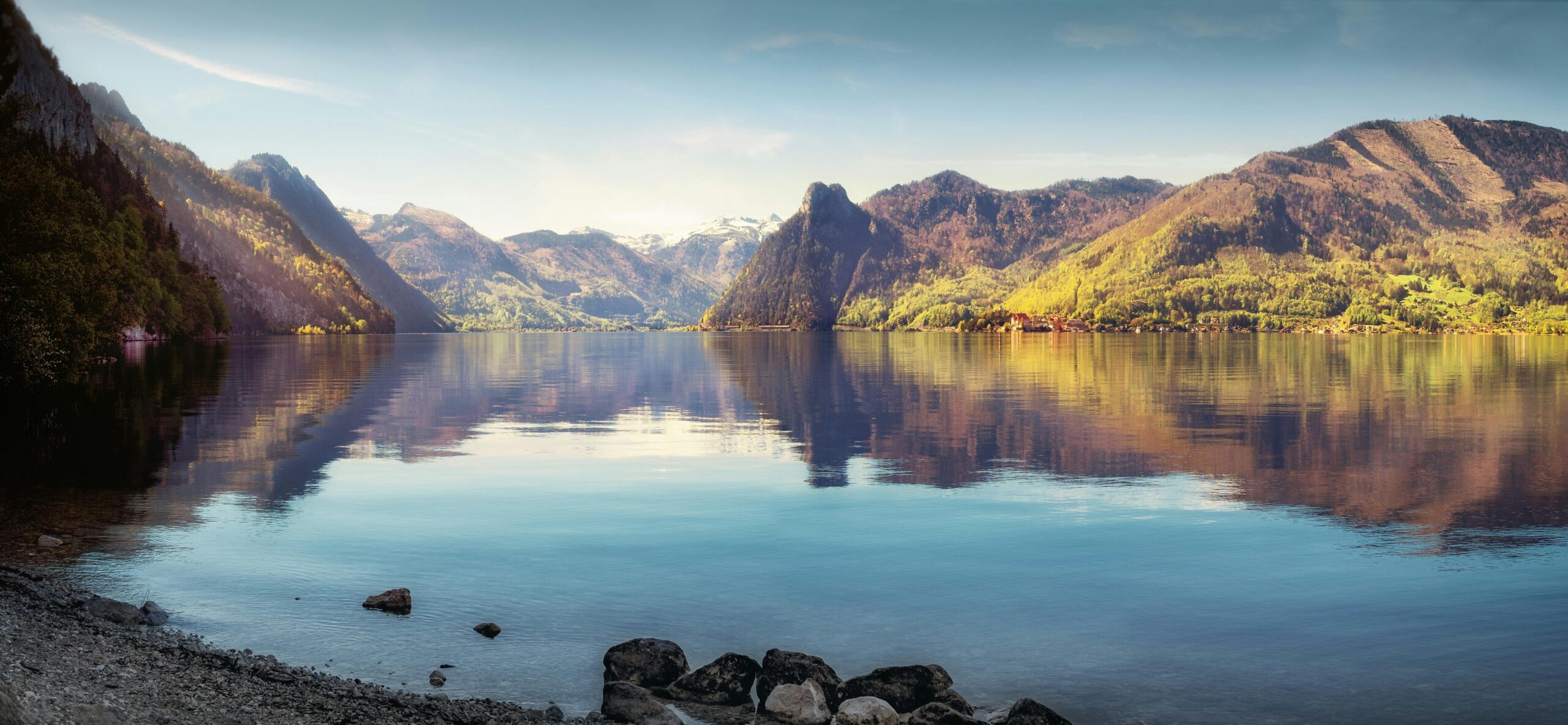 Peisaj montan seren cu un lac oglindă, reflectând liniștea pe care o căutăm în practica mindfulness