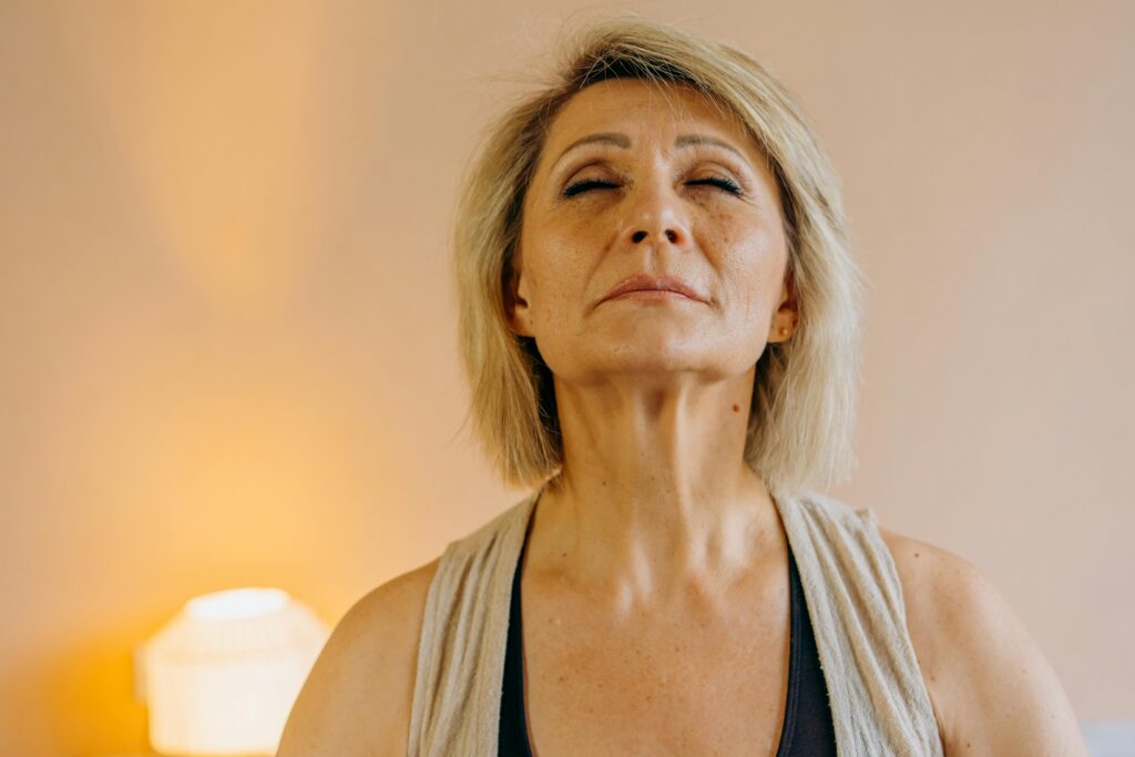 Femeie practicând mindfulness acasă, regăsindu-și liniștea interioară
